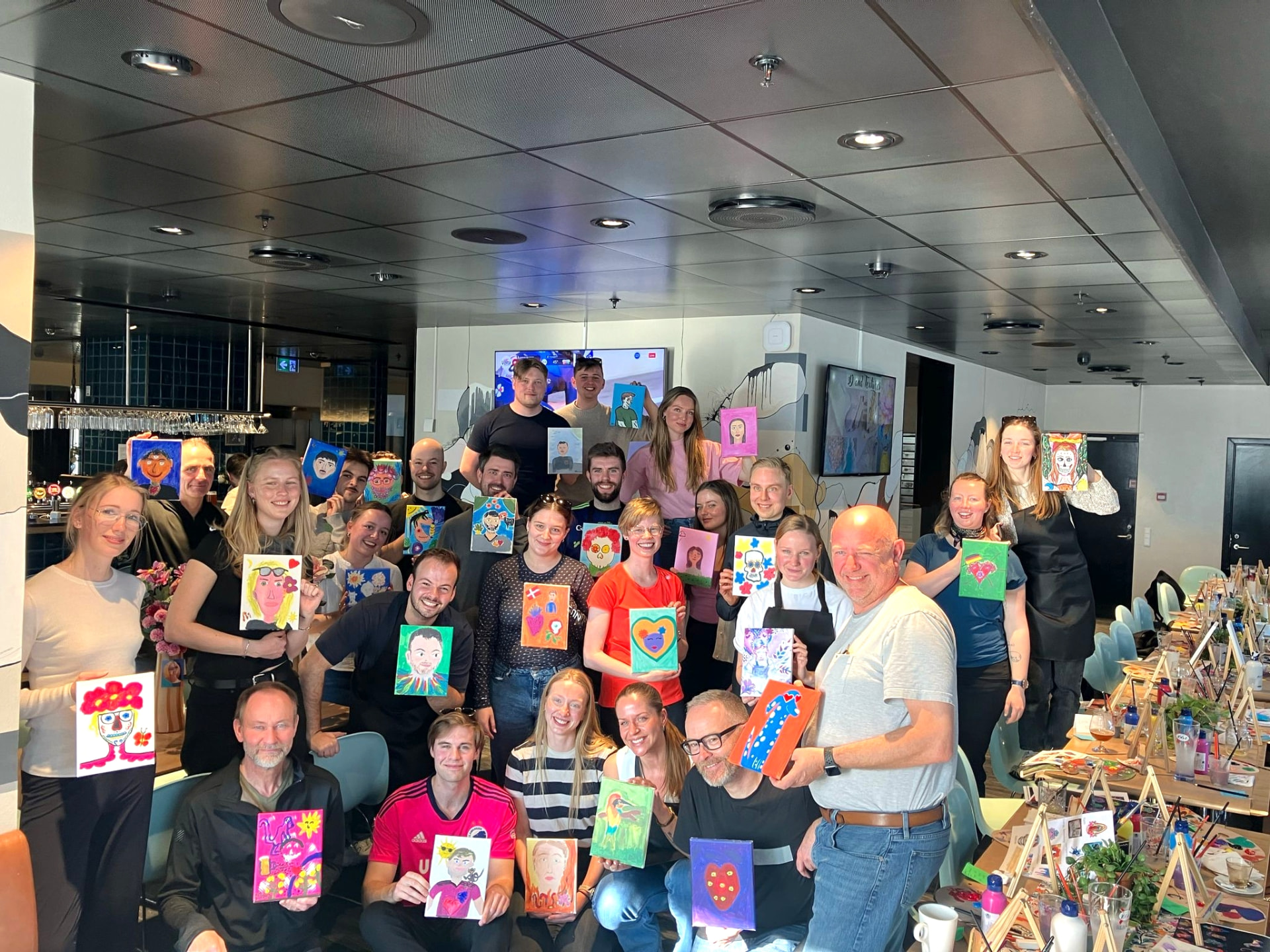 A large company group painting together at a Painting & Wine event in Copenhagen